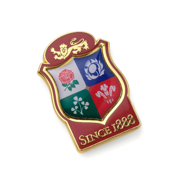 Shield-shaped badge with a lion emblem, rose, rugby ball, and leek symbols on a white background.
