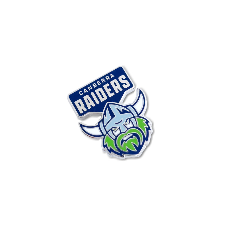 A pin badge featuring the Canberra Raiders logo with a stylized Viking helmet design in blue, white, and green colors.
