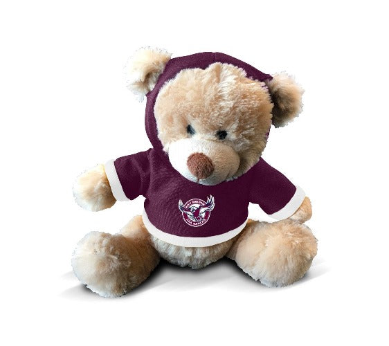 A plush teddy bear wearing a maroon hoodie with the Manly Sea Eagles logo on the front.
